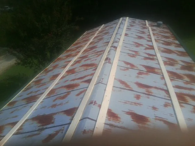 Rusted metal roof panels with new wood purlins before replacement — Storm Damage Roof Repair in Orange by Roofing Brothers